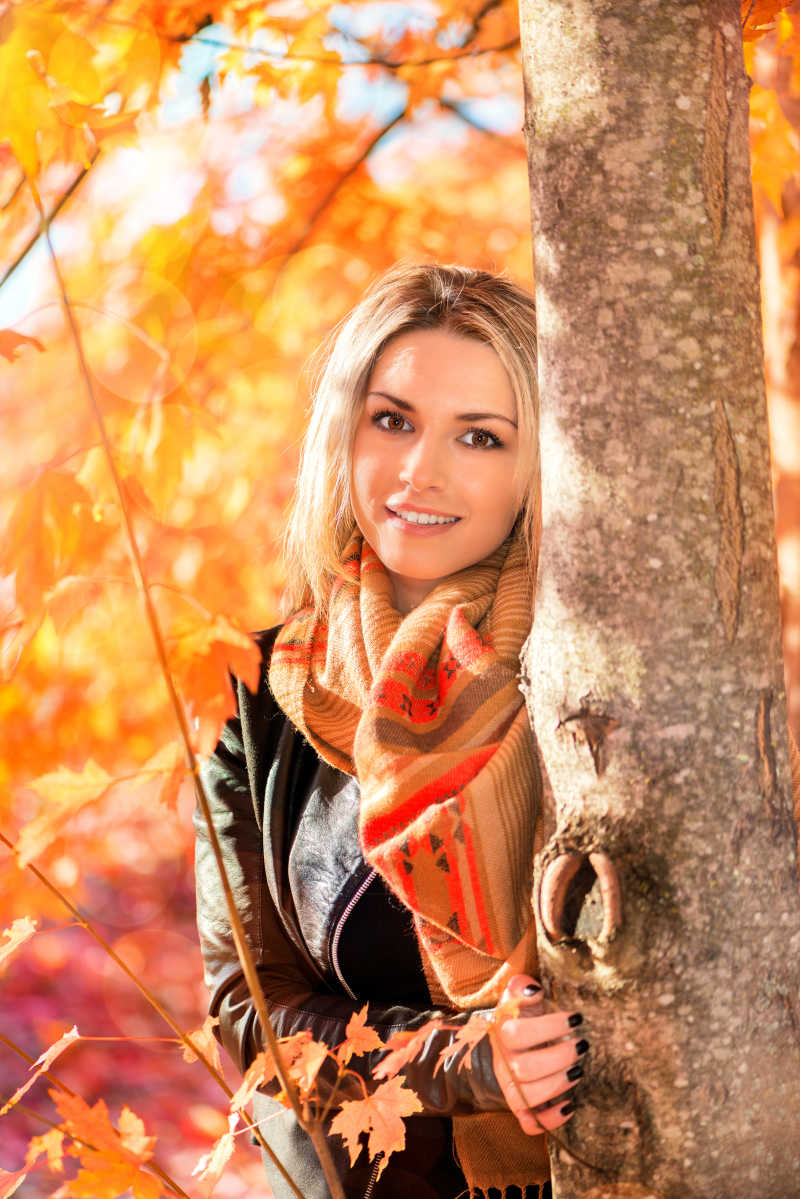 秋天树林里站在树旁的美女