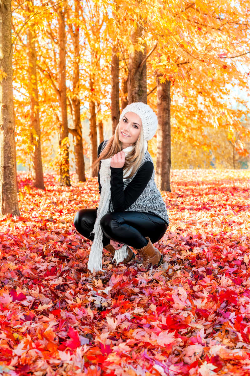 秋天树林里蹲在地上的美女