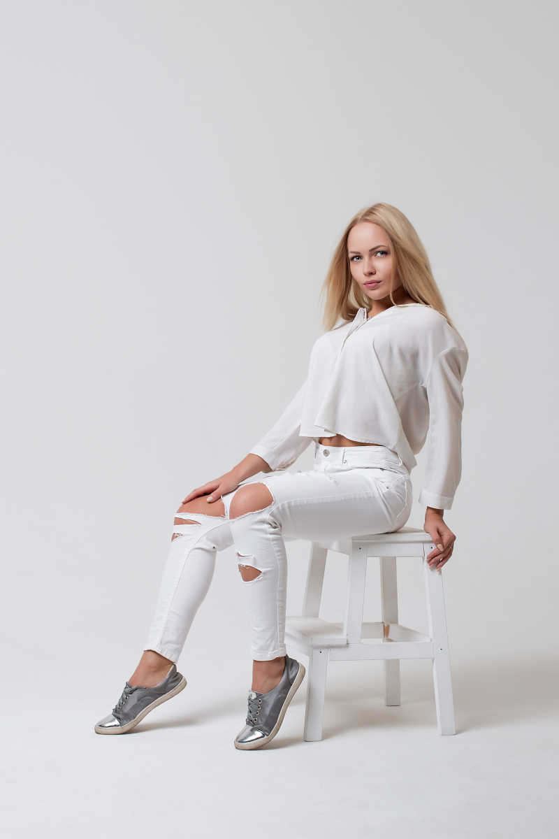穿白色内衣的金发美女模特坐在椅子上