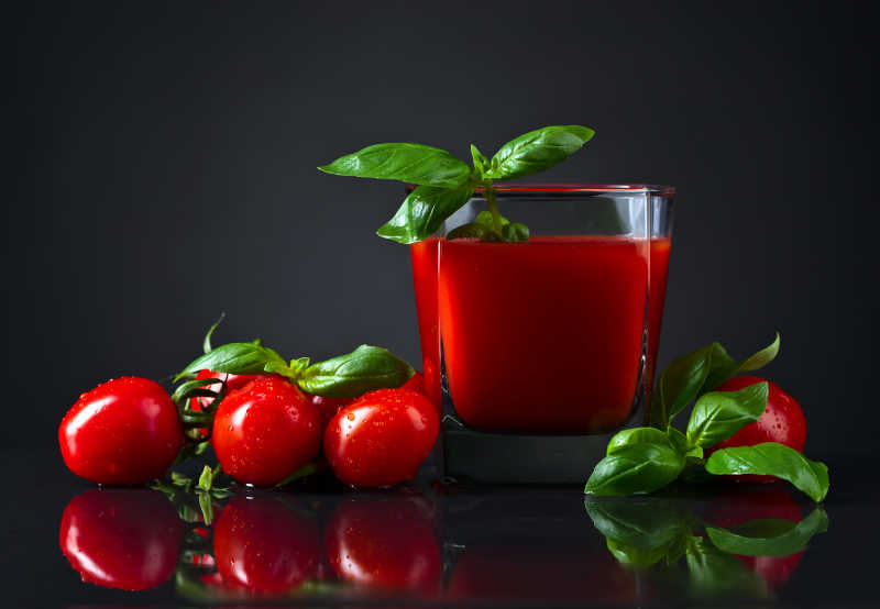 透明杯里的红色番茄汁和小番茄