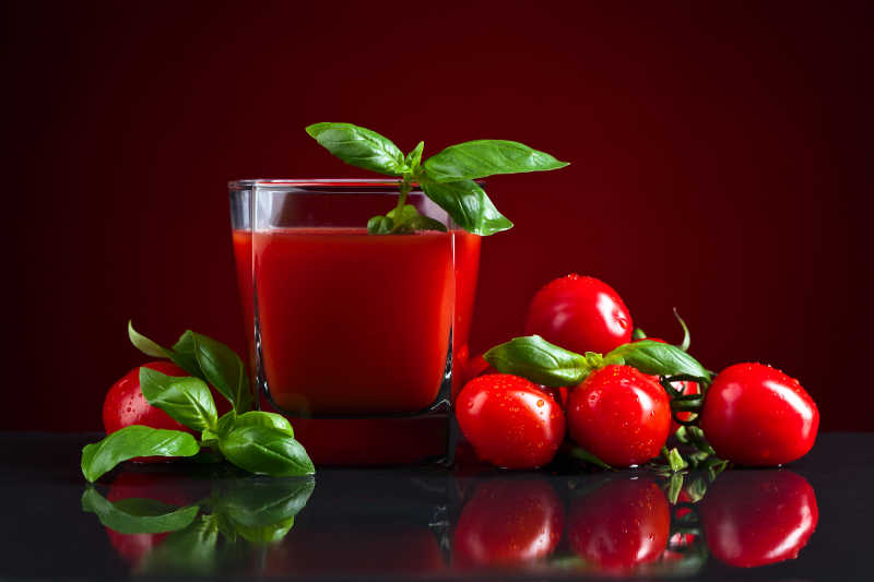 杯子里的番茄汁和旁边的红色小番茄