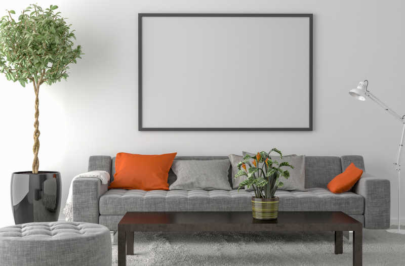灰色沙发和墙上的空白画框