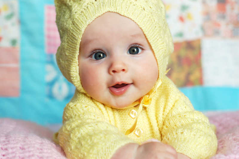 可爱的大眼镜女婴穿着黄色毛衣