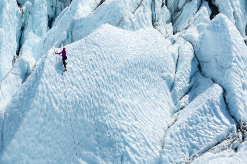 孤独的登山者到达了一个冰山的顶端