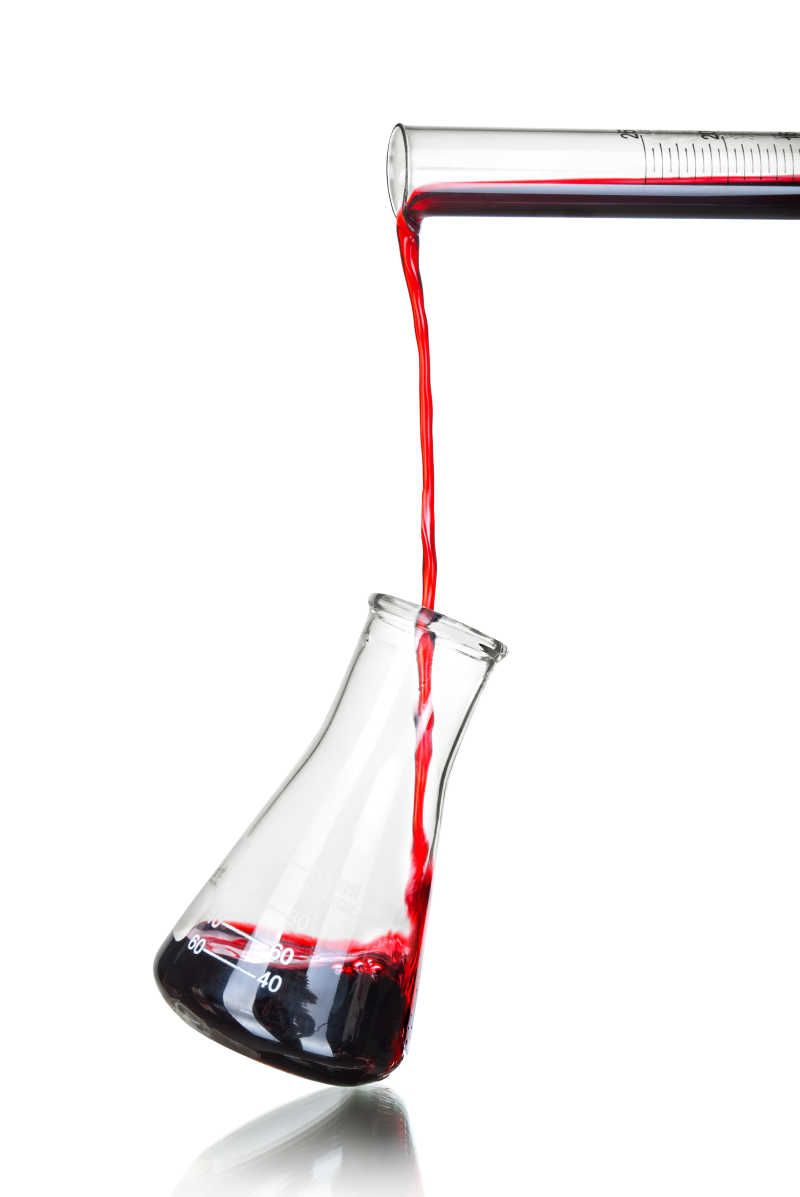 白色背景下红色液体从试管里导入玻璃器皿里