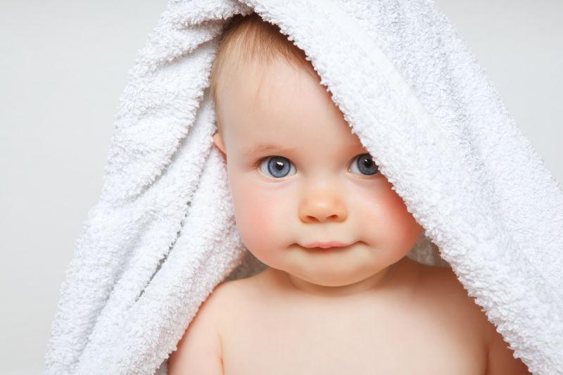 顶着白色浴巾的婴儿