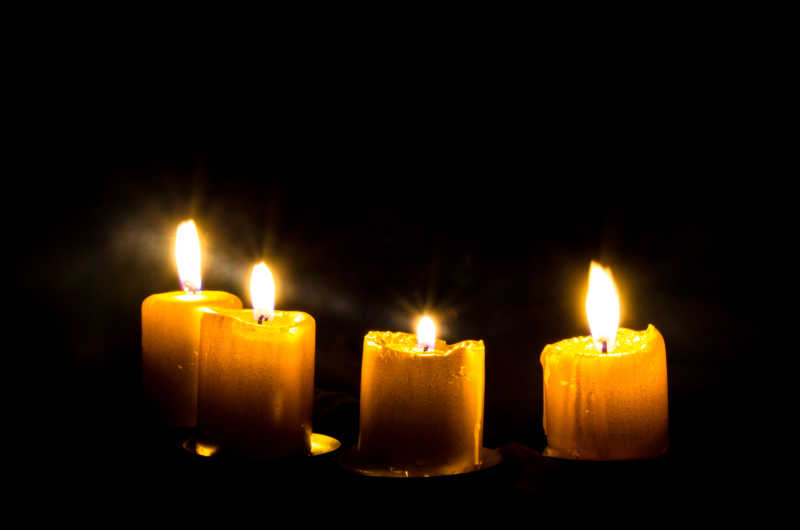 黑色背景下的四根白色蜡烛