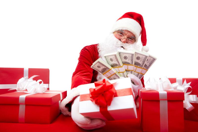 白色背景下举着钞票的圣诞老人和圣诞礼物