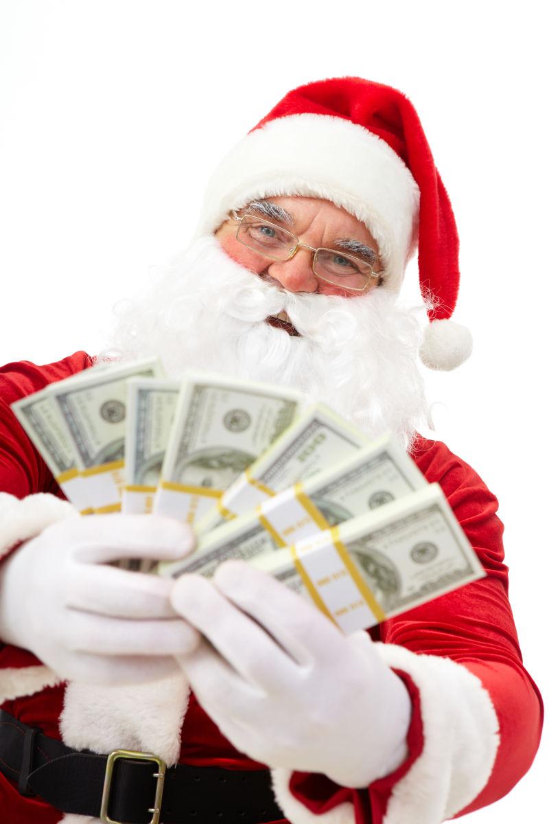 白色背景下的举着美元现金微笑的圣诞老人