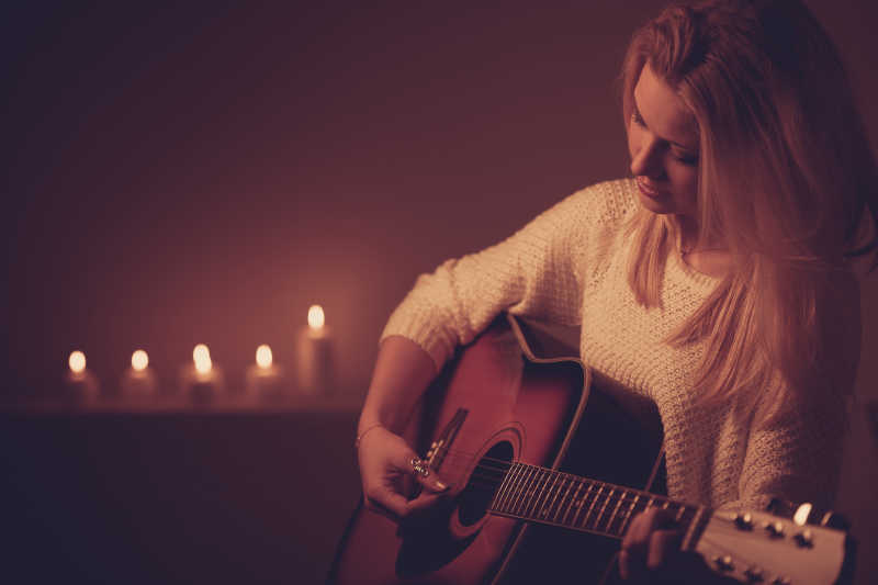 在烛光下弹吉他的美女