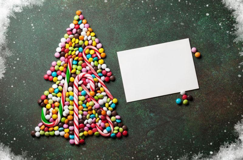 组成圣诞树形状的糖果与贺卡
