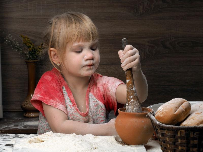 沾满面粉的小女孩在制作面团