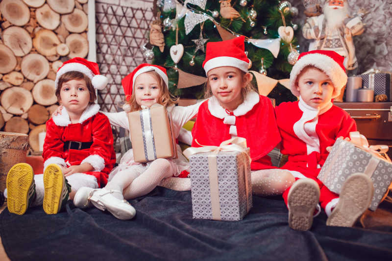 圣诞老人装扮拿着礼物的孩子们