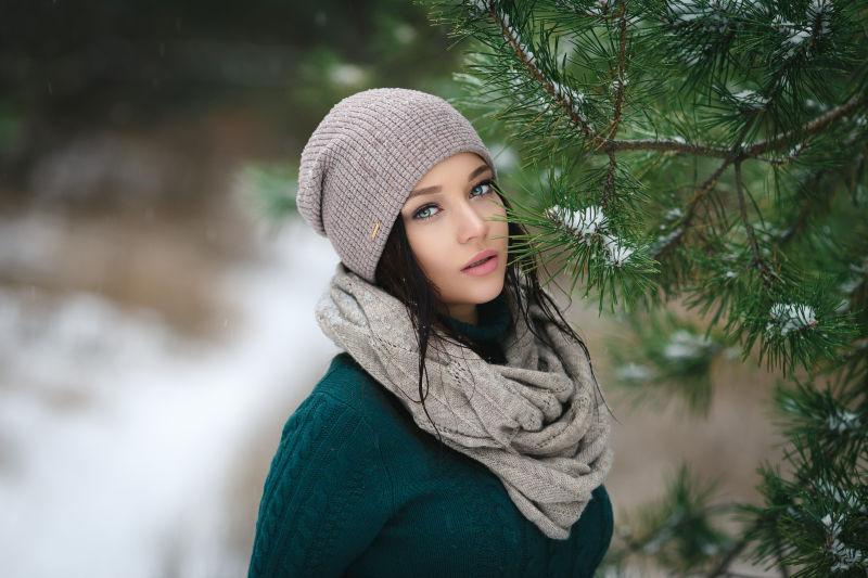 冬季在雪地里松树旁边照相的美女