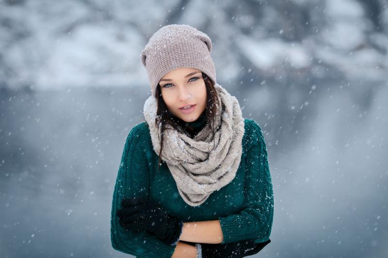 冬季雪地里穿蓝色毛衣的美女