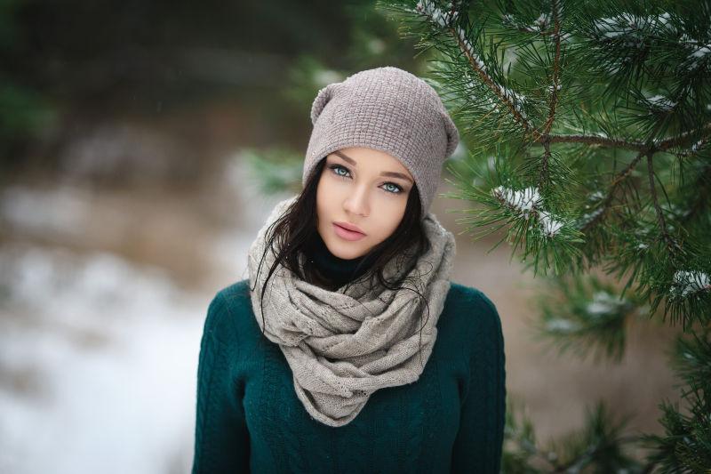 在冬季室外戴帽子的美丽的年轻女子