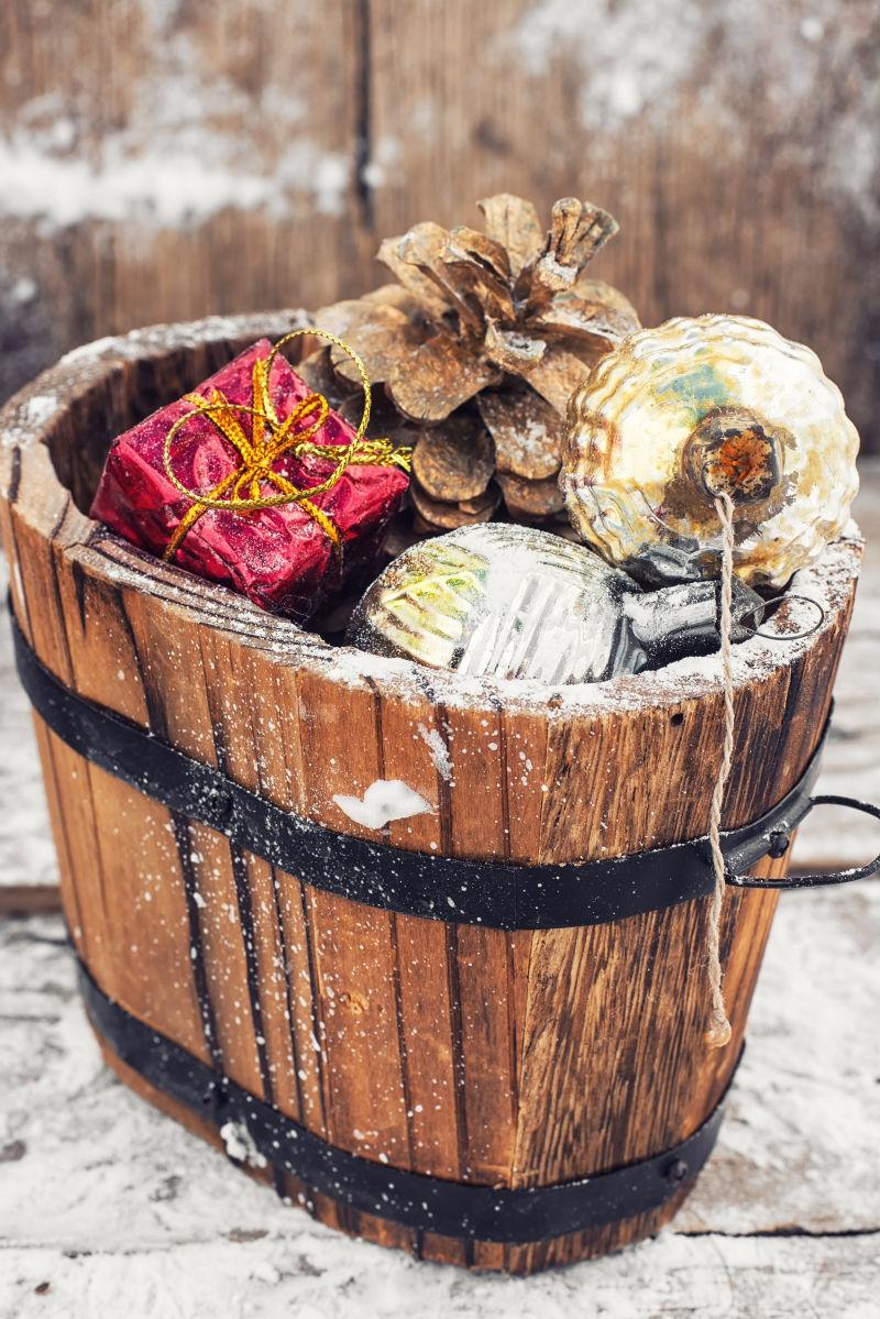 装满圣诞饰物和松果的装饰木桶