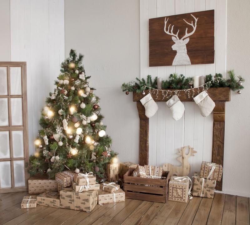 明亮的室内放着圣诞礼物盒和挂着小灯的圣诞树