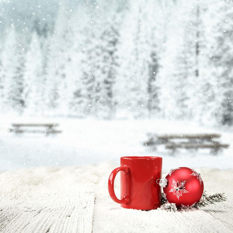 冬季下雪天户外的红色杯子和圣诞装饰品