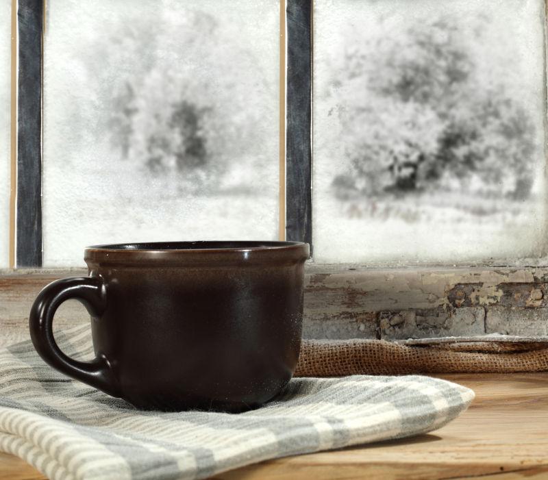 寒冷冬季窗户胖的棕色杯子