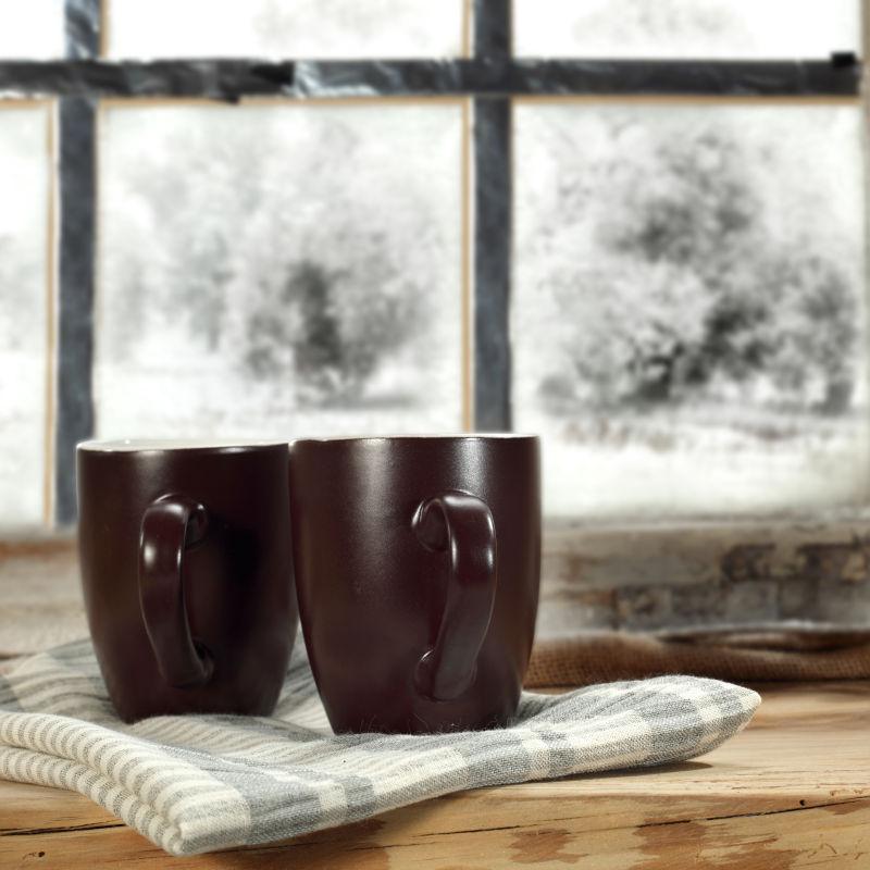 冬季窗户旁两个棕色杯子