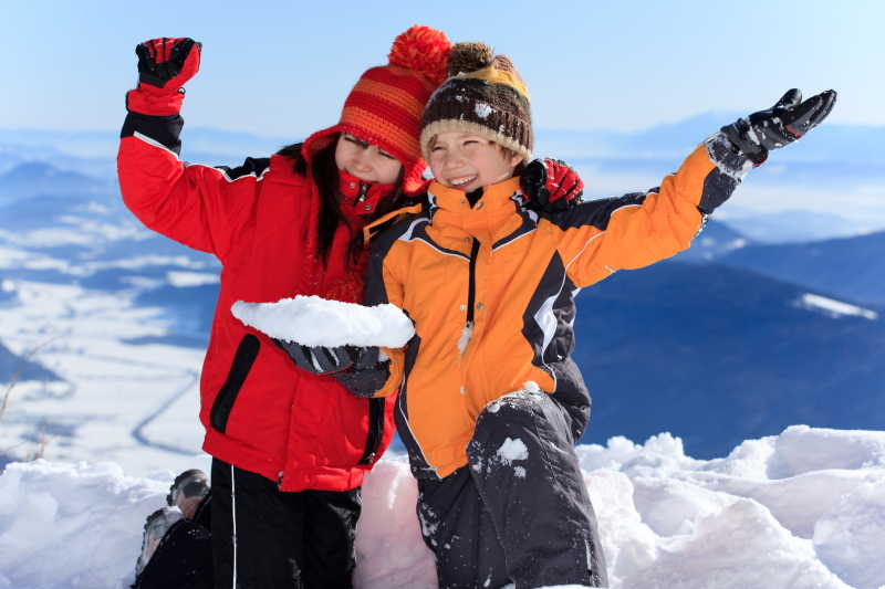 在山顶玩雪的两个小女孩