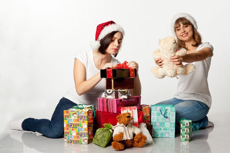 两个微笑的圣诞女孩解开礼物