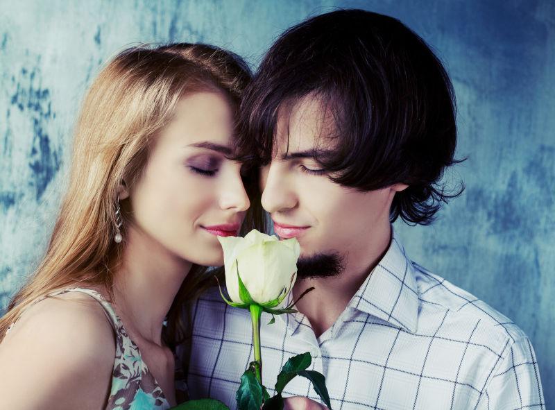 情侣闻着玫瑰的照片