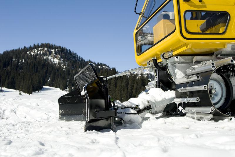 雪山上正在铲雪的拖拉机