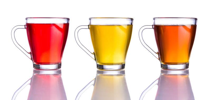 白色背景上玻璃杯中不同颜色的三种茶