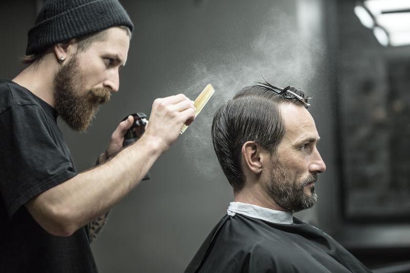大胡子男性理发师正在给男性顾客理发