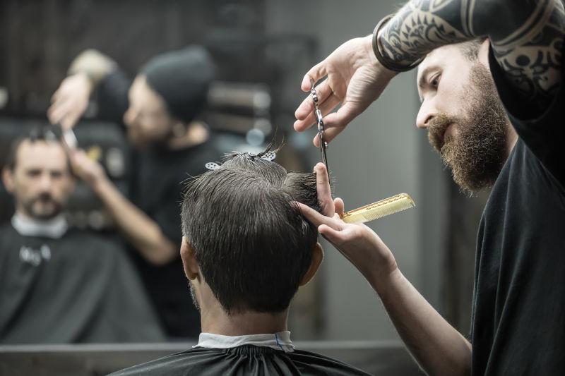 一位身材魁梧的理发师在给顾客理发