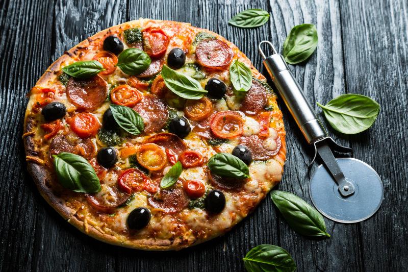 木制背景下美味的意大利腊肠番茄披萨